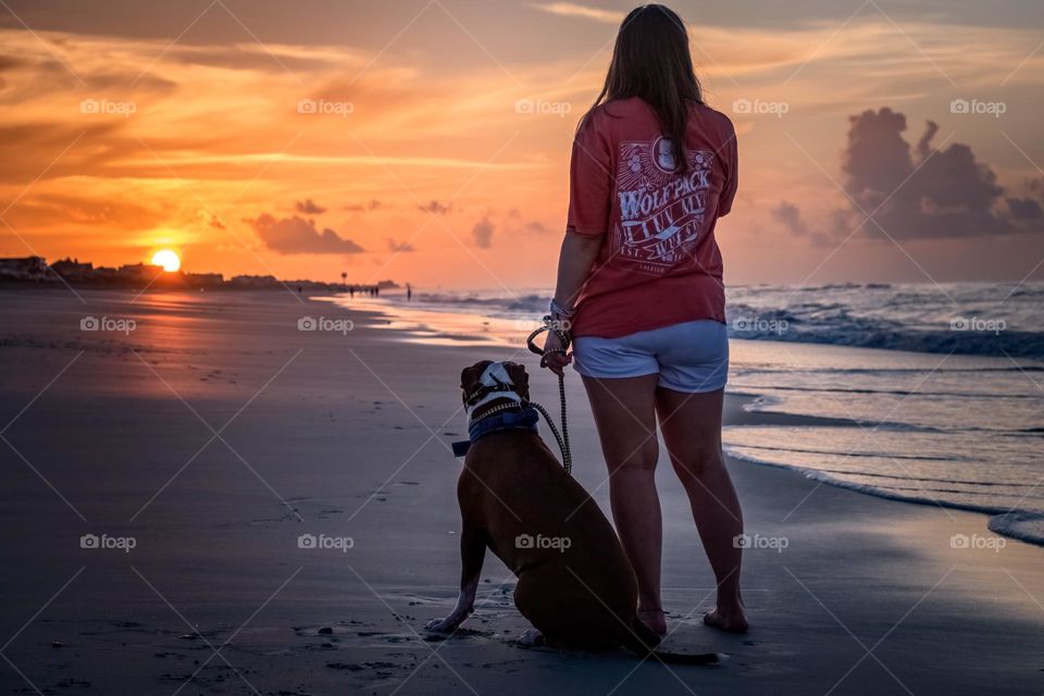 Best friends enjoy an early morning walk on the beach. Emerald Isle, North Carolina. 