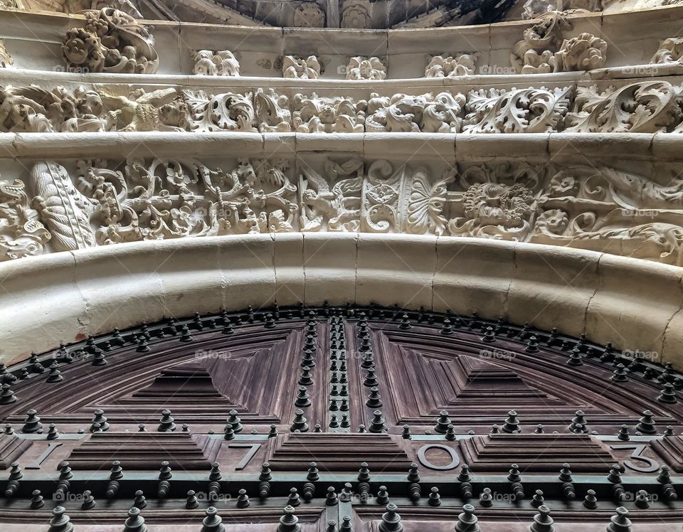 Large wooden door dated 1703, with ornate stonework above it at Convento de Cristo, Tomar, Portugal 