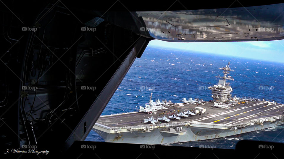 After taking off from a aircraft carrier in a CV22 Osprey the aircraft carrier is visible through the open back ramp