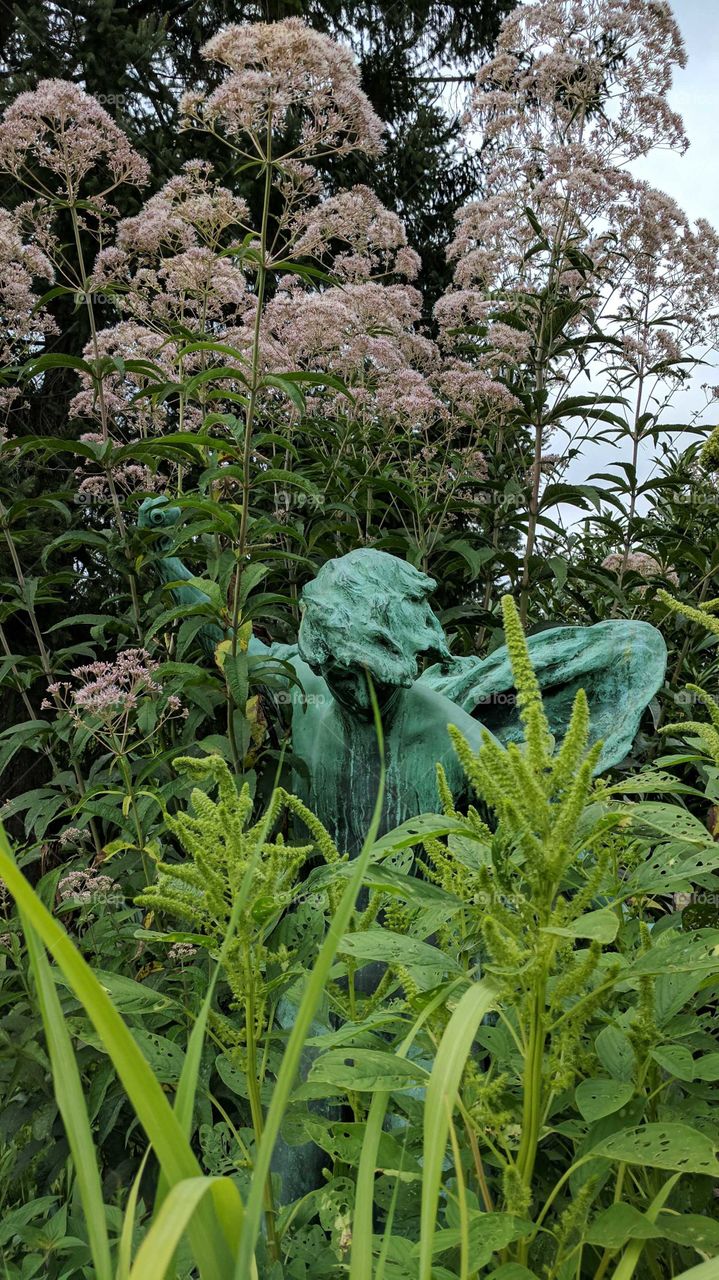 Statue hidden in Flora, Queens Botanical Garden