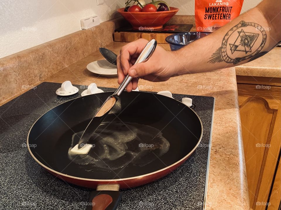 Prepping the skillet with fresh butter for home cooking