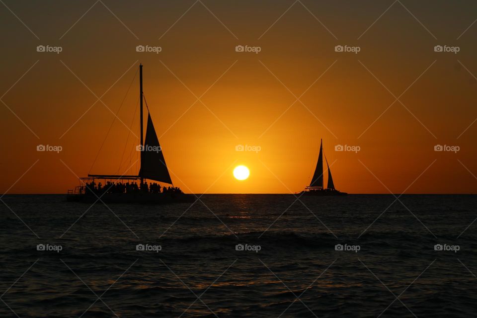 sailing boats at sunset in the horizon