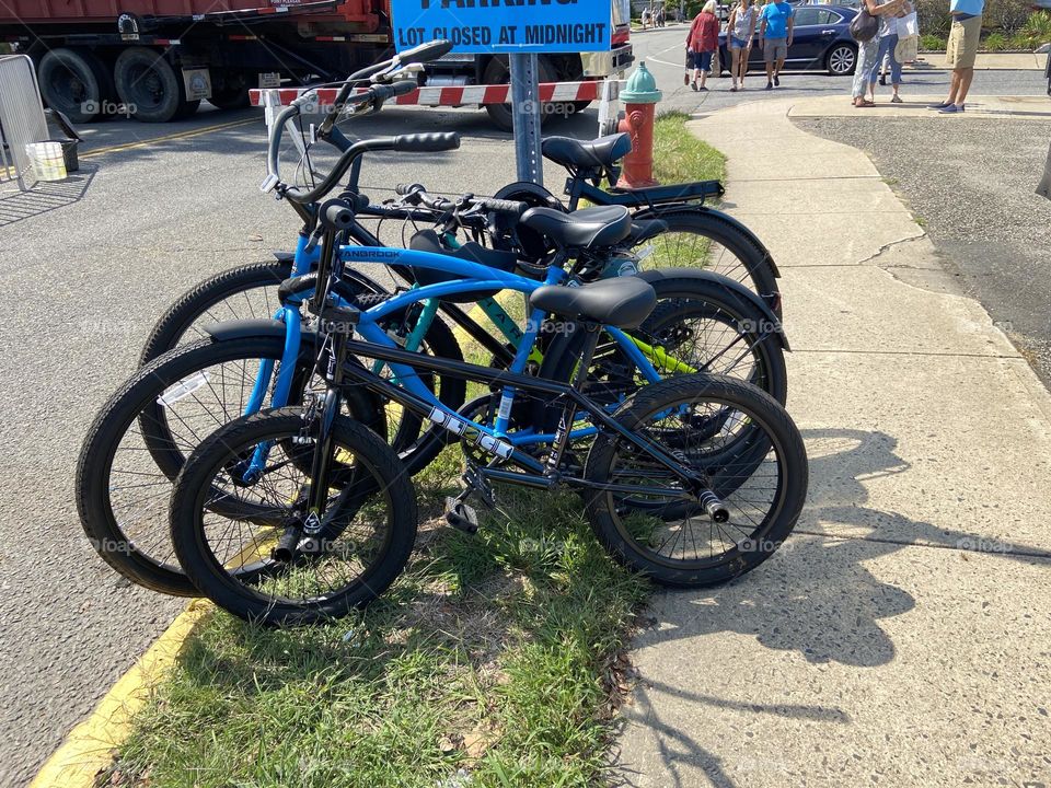 Bikes secured to a sign and sitting on the grass at a recent festival I attended in Point Pleasant Beach, NJ. They were smart to ride their bikes since parking gets challenging at this extremely popular “Festival By The Sea.”