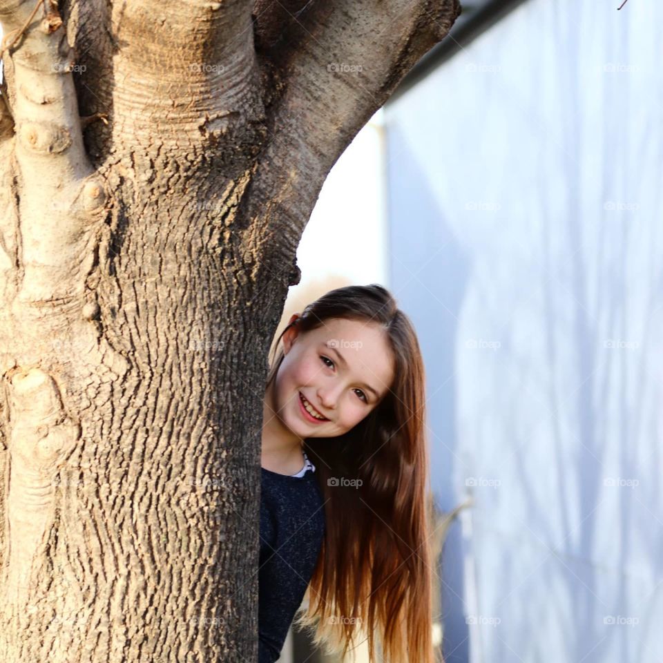 girl looking out from a tree