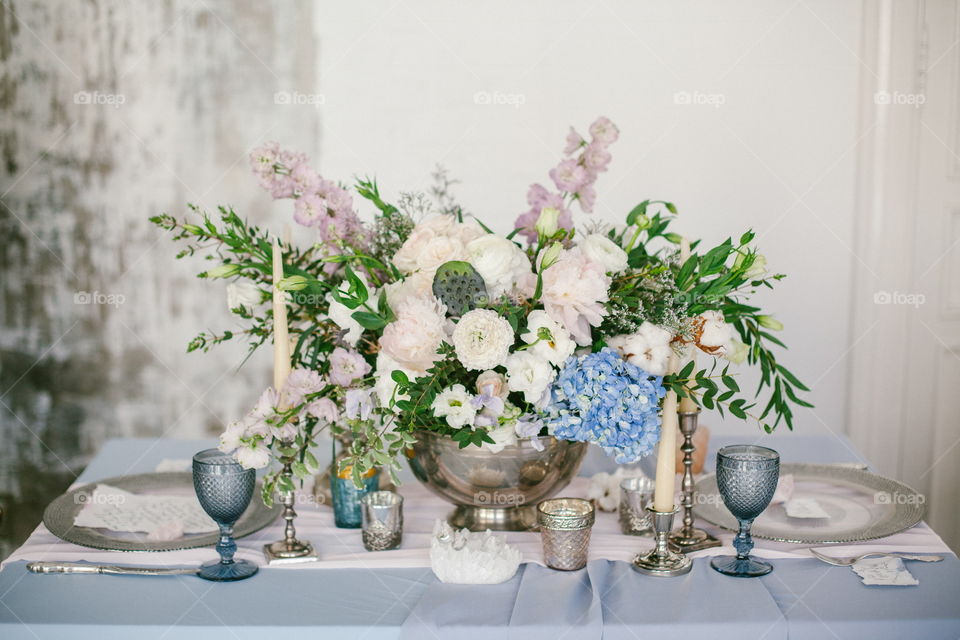 Silver candlestick and other elements of festive table wedding centerpieces decorations.