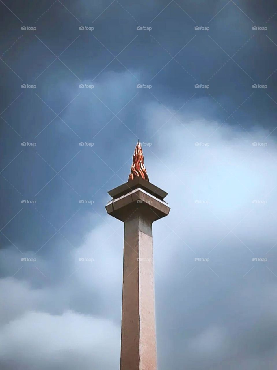 Close-up view of Monas (National Monument) with a cloudy sky in the background in low angle view