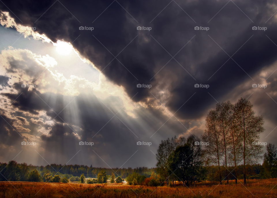 Fantastic cloudy sky over autumn field 