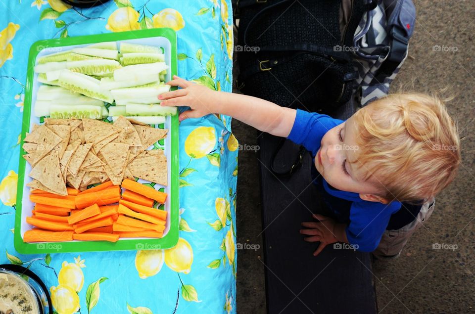Elevated view of little boy eating healthy food on plate