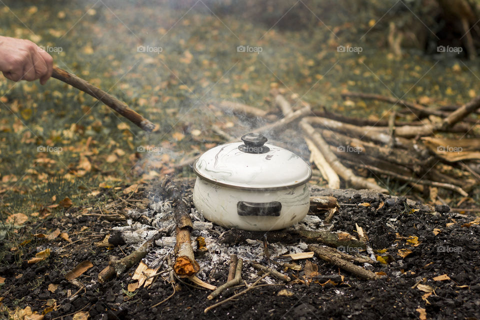 Cooking in a pot on campfire in the nature