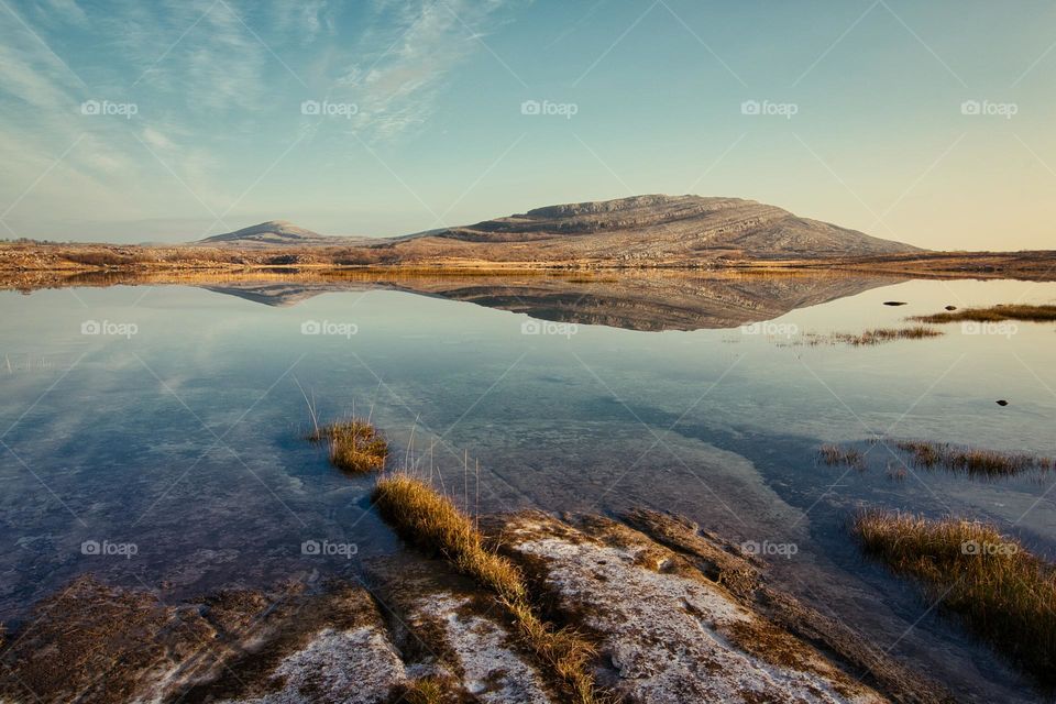 Beautiful morning landscape scenery with mountains reflected in Lake at Burren National Park in county Clare, Ireland