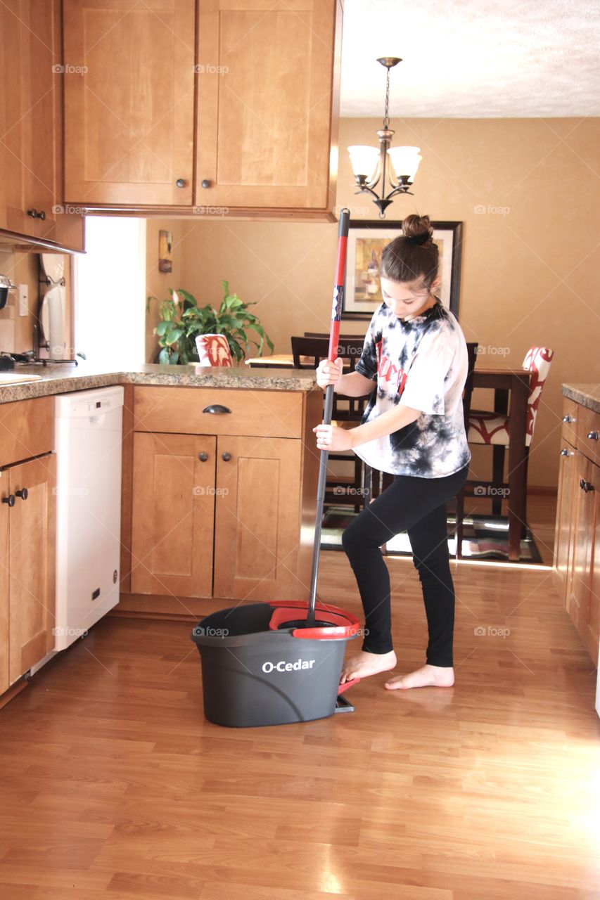 Girl using O-Cedar mop and bucket 