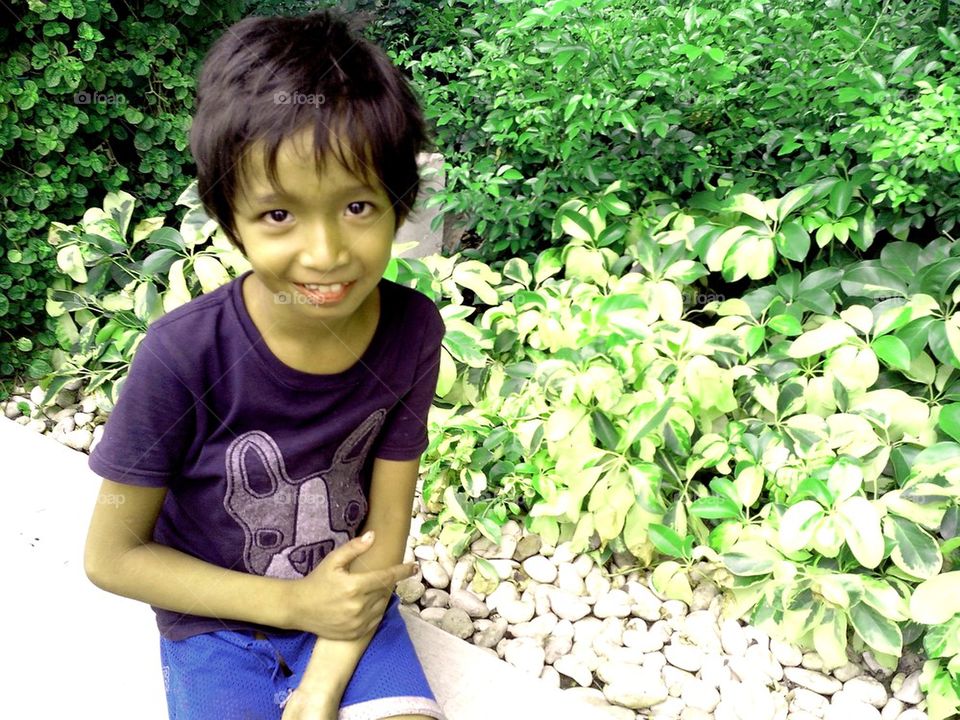 asian girl sitting by a plant box