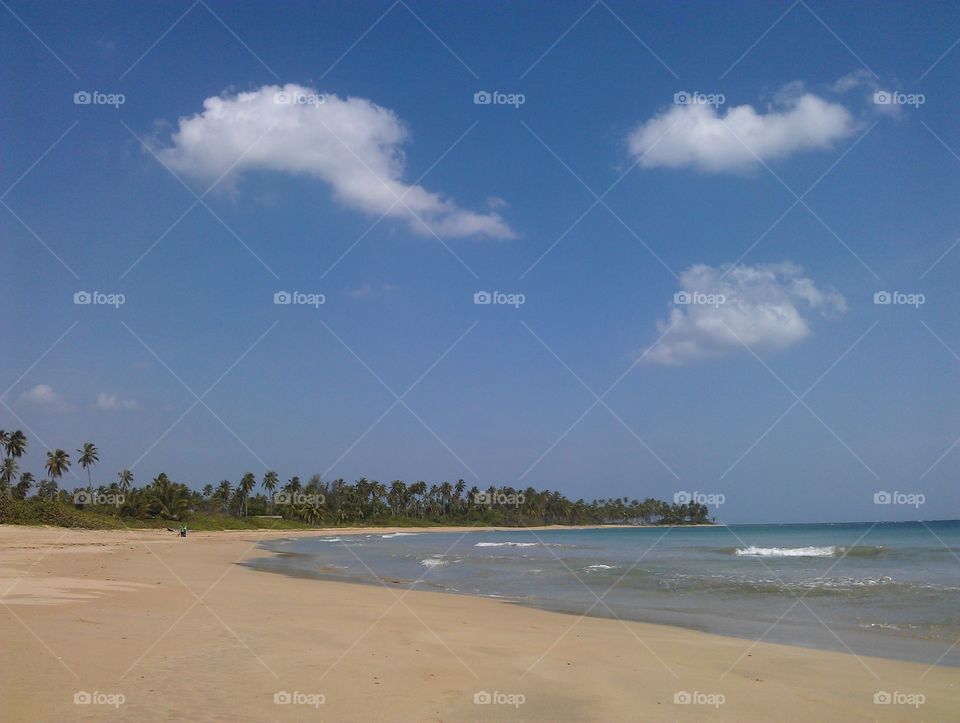 beautiful caribbean beach with sand sea sky and clouds. sandy beach in a gorgeous bay