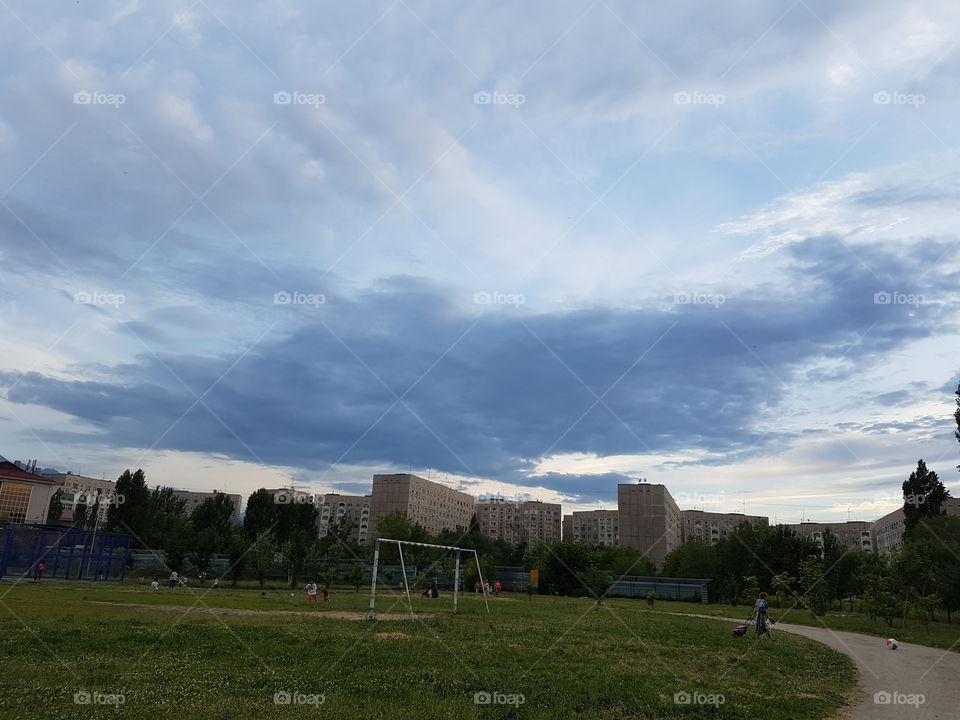 old stadium in residential area with huge cloud