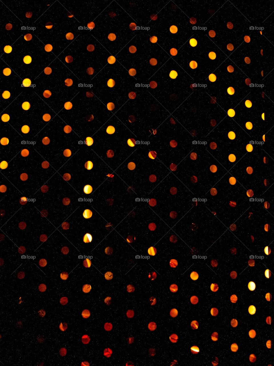 Orange and yellow circle shapes using fire in a black burner. Multi colored circles.