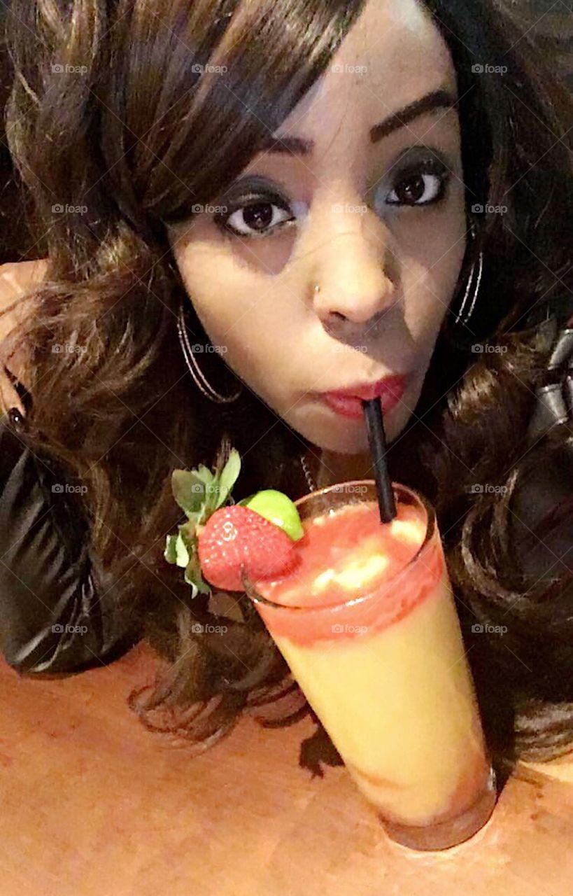 Beautiful lady sipping on a sweet fruit alcohol drink