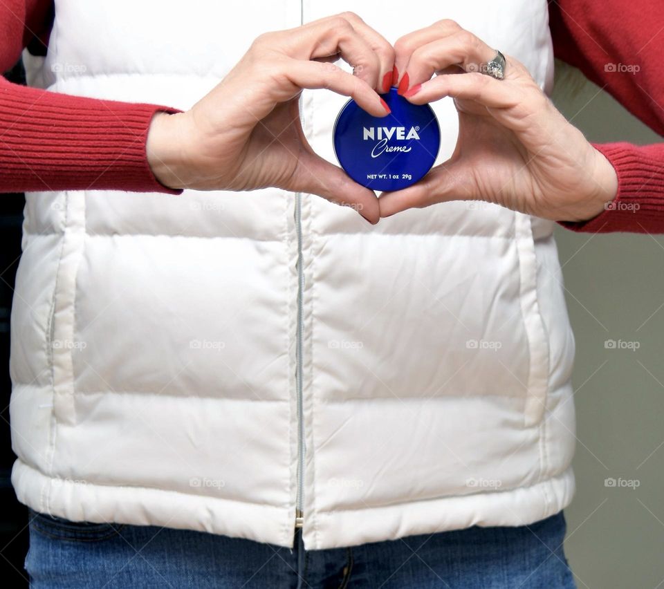 Heart shaped hands holding Nivea moisturizer 