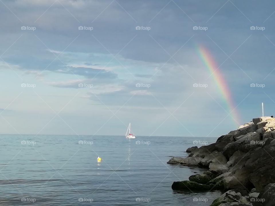 Rainbow, boat an a ray of light