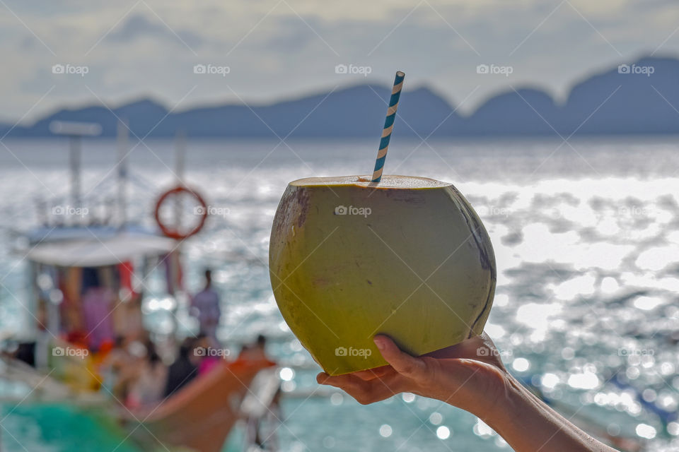 Enjoying coconut water on a tropical beach