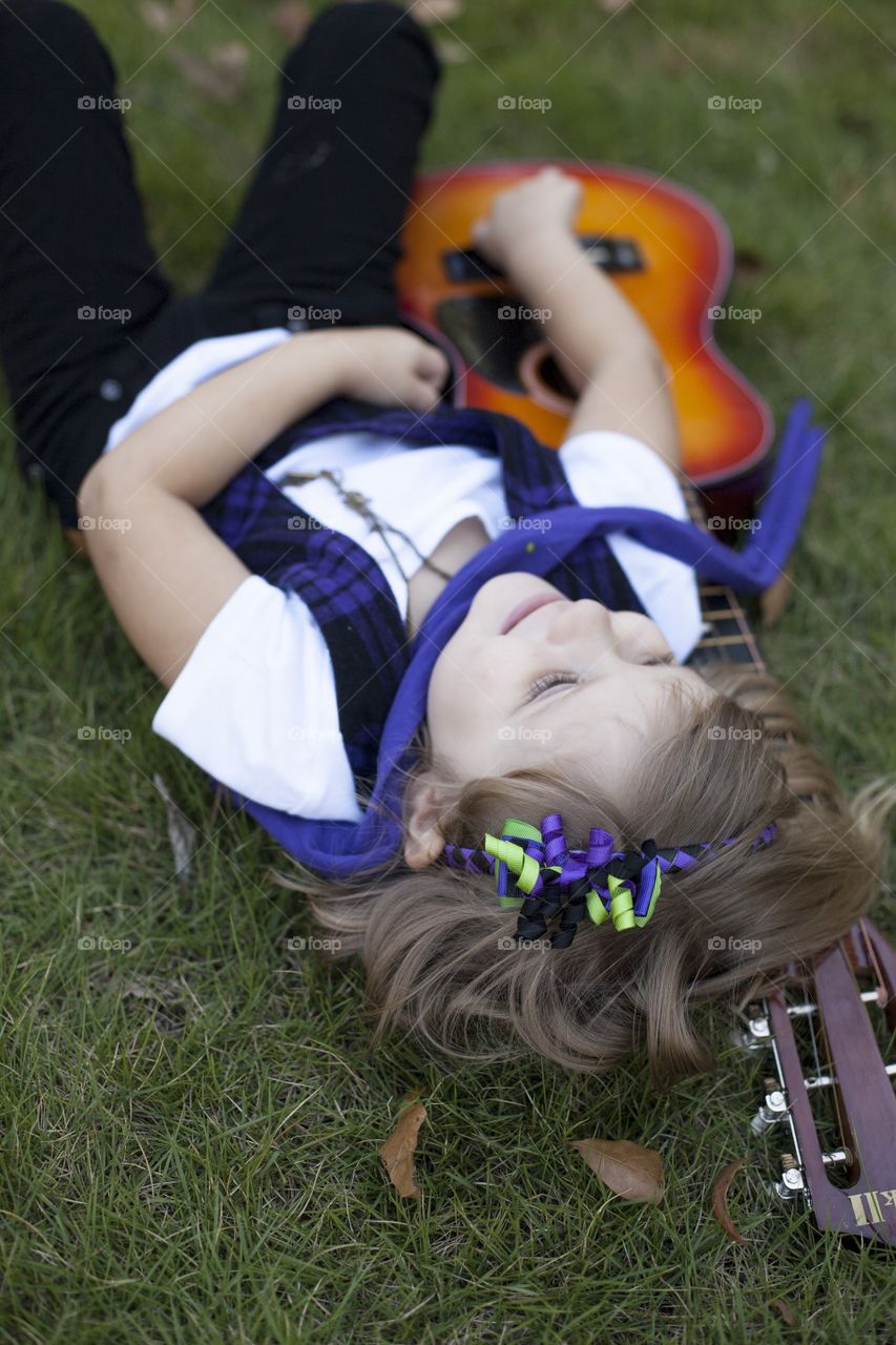 Girl lying on grass with guitar