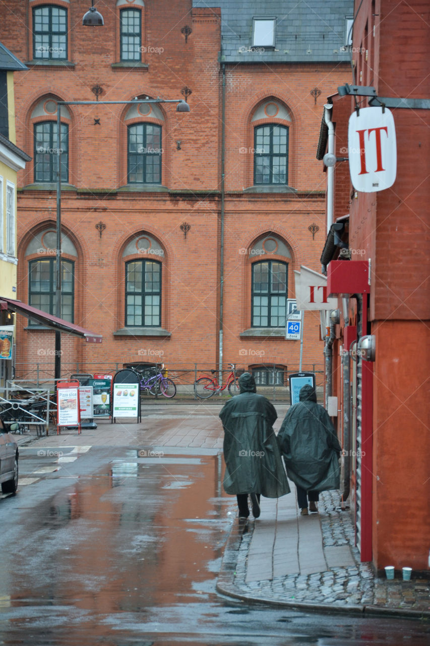 Two people walking in the rain at Dragör in Denmark.