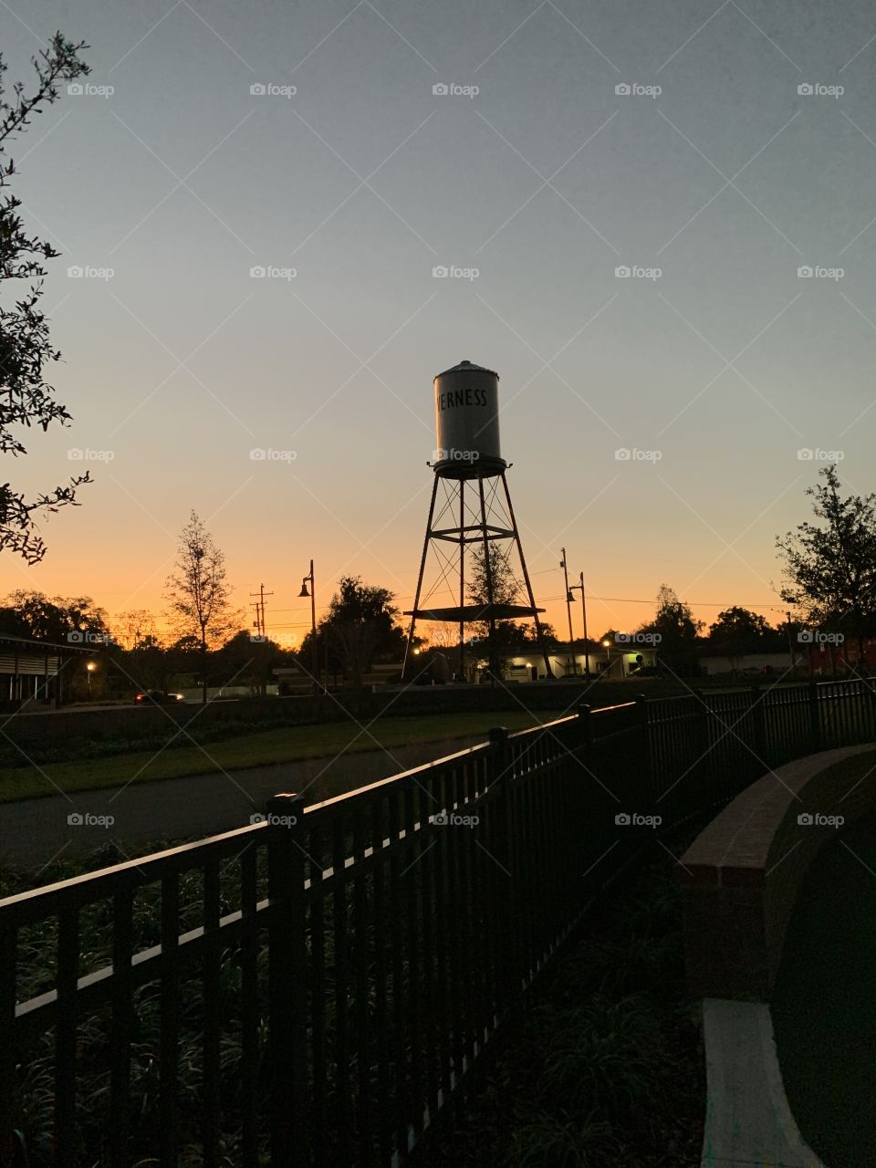Our town water tower silhouetted against the darkening sky. A faint orange glow emanating from the horizon. 
