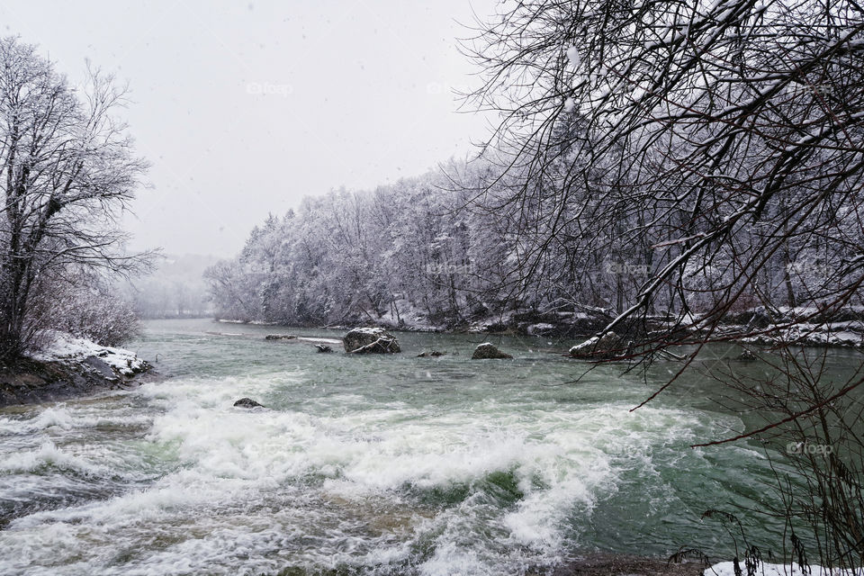 Isar river in winter. snowing. licated in bavaria, germany. next to village pullach.