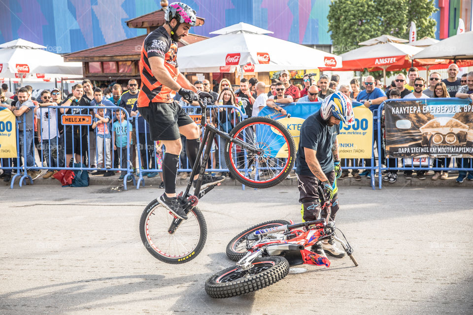 Doing Acrobatics With Bicycle In Front Of Crowd
