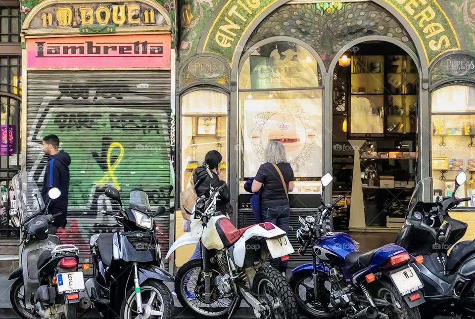 Motorbikes & scooters parked up outside shops in Barcelona 