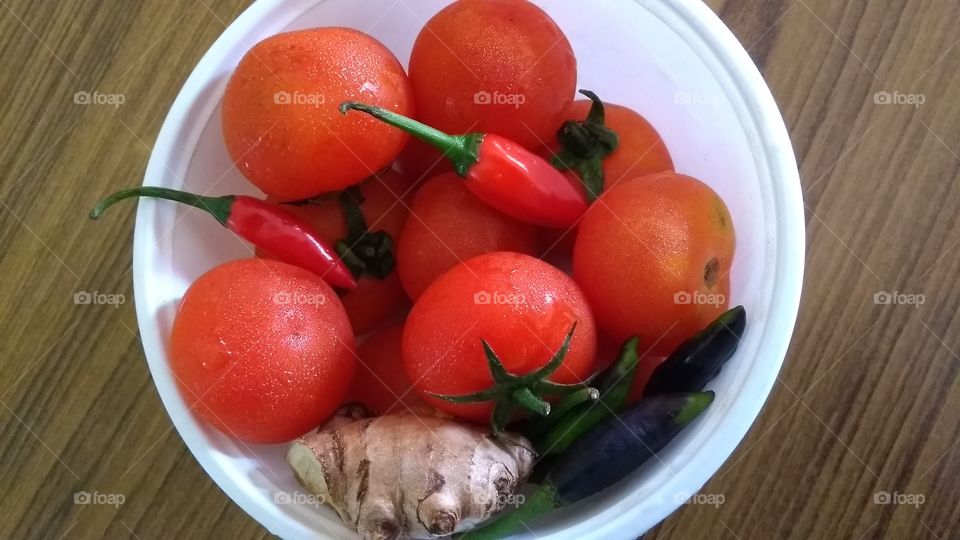 The freshness greeting you everyday in your food. Tasty tomatoes, chillies and ginger all sitting gracefully in the container.