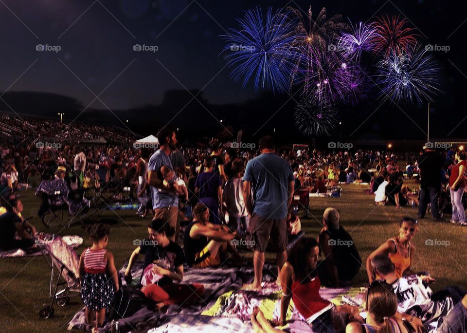 Crowd of people watching a fireworks celebration.