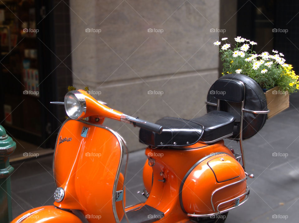 Small flower bouquet on a orange Vespa