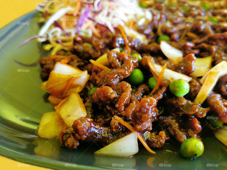 Crispy shredded beef in a green plate.