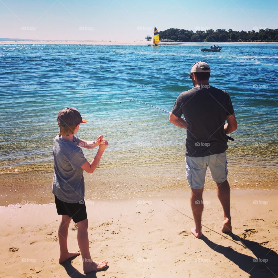 Fishing with dad at the sea in summer 