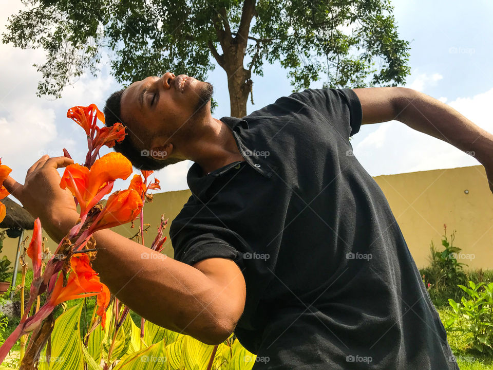 Man dancing with flowers in nature area 