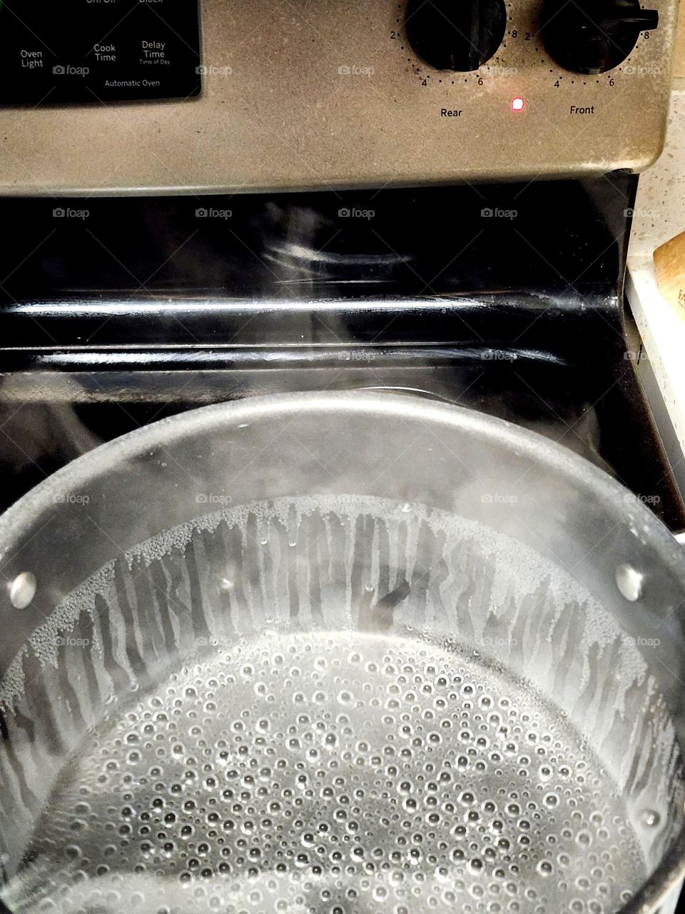 small bubbles in a pot of boiling water on a home kitchen stovetop in preparation for a meal