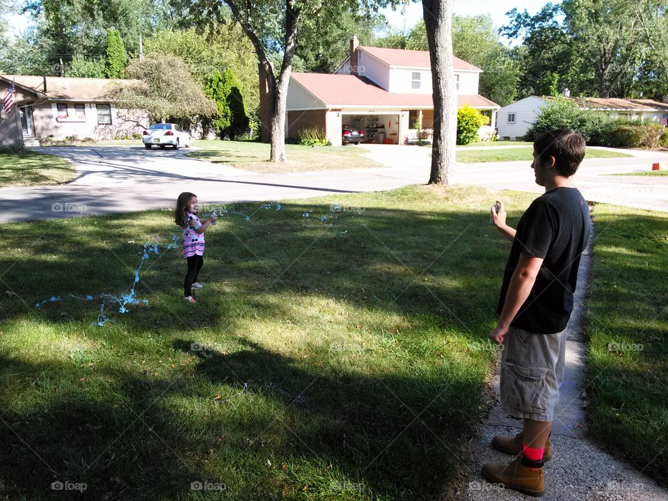 silly string war. kids chasing each other with silly string