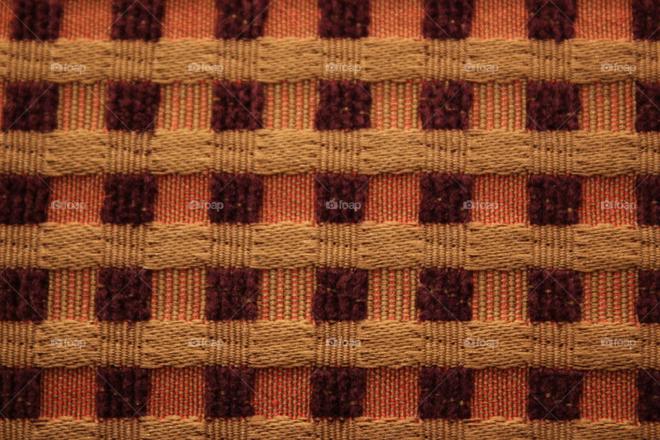 Yellow, brown and orange checked patterned pillow close-up