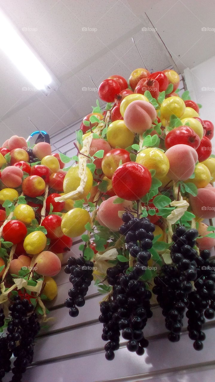 Many ornament fruits hanging in shop
on wall