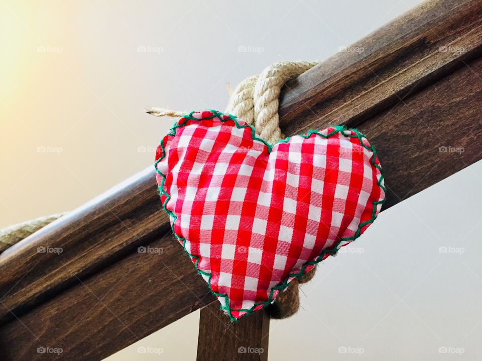 Heart shaped material decorating a wooden railing 