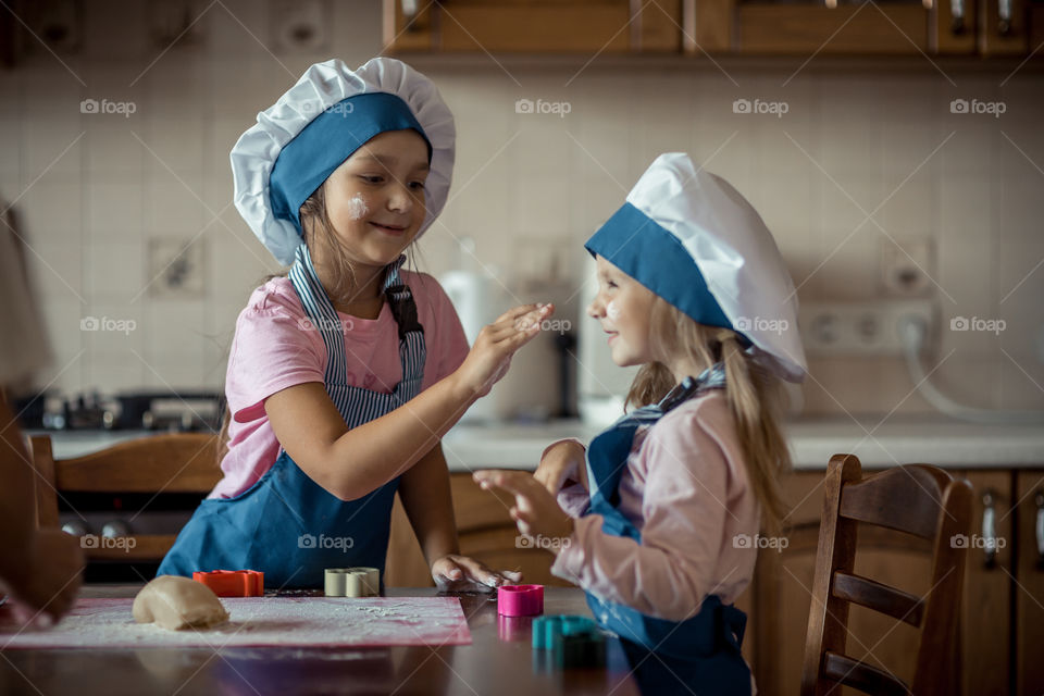 Little sisters cooking the biscuits 