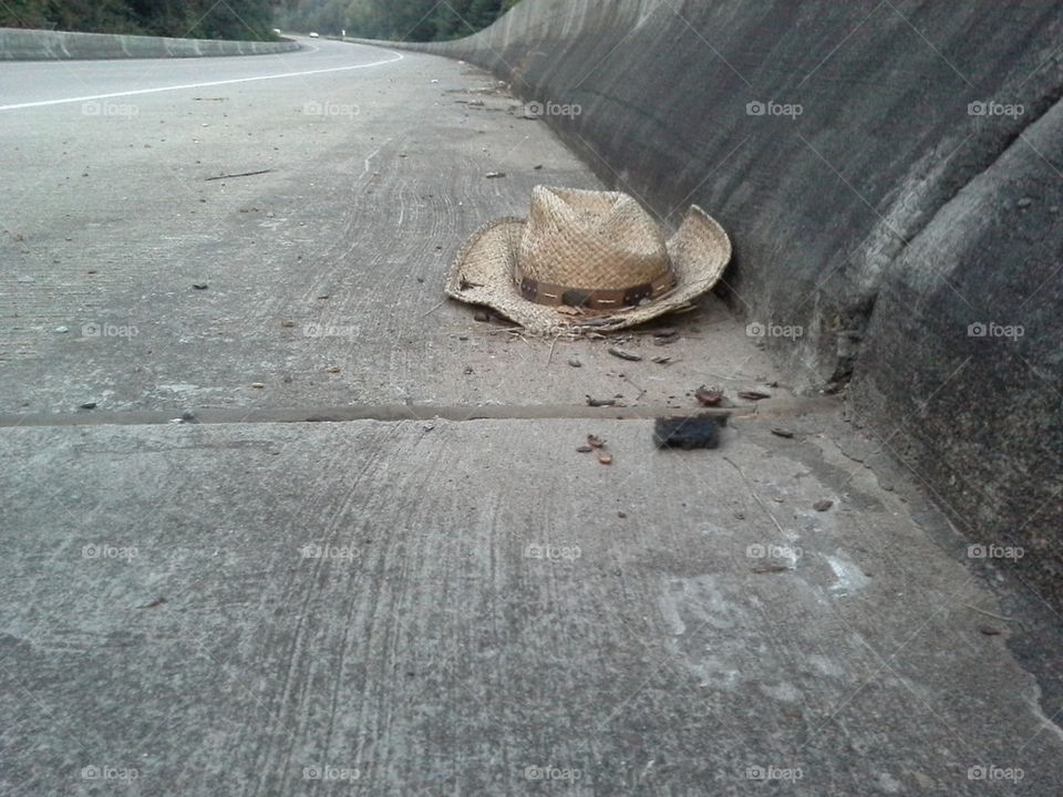 A straw hat on an asphalt trail