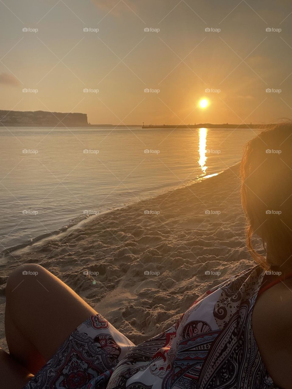 Girl on the beach watching the sunset 