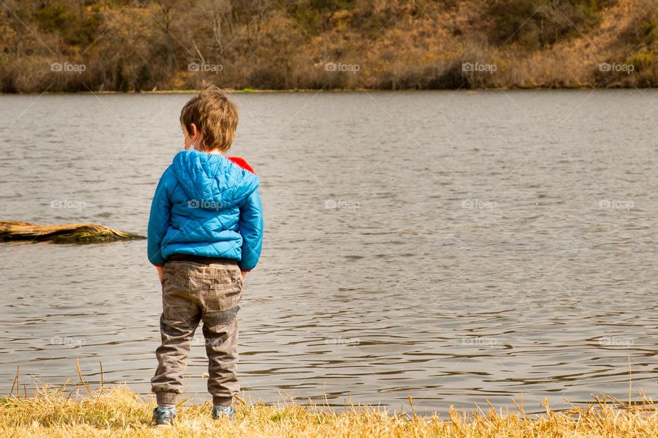 Boy next to water, a moment of peace