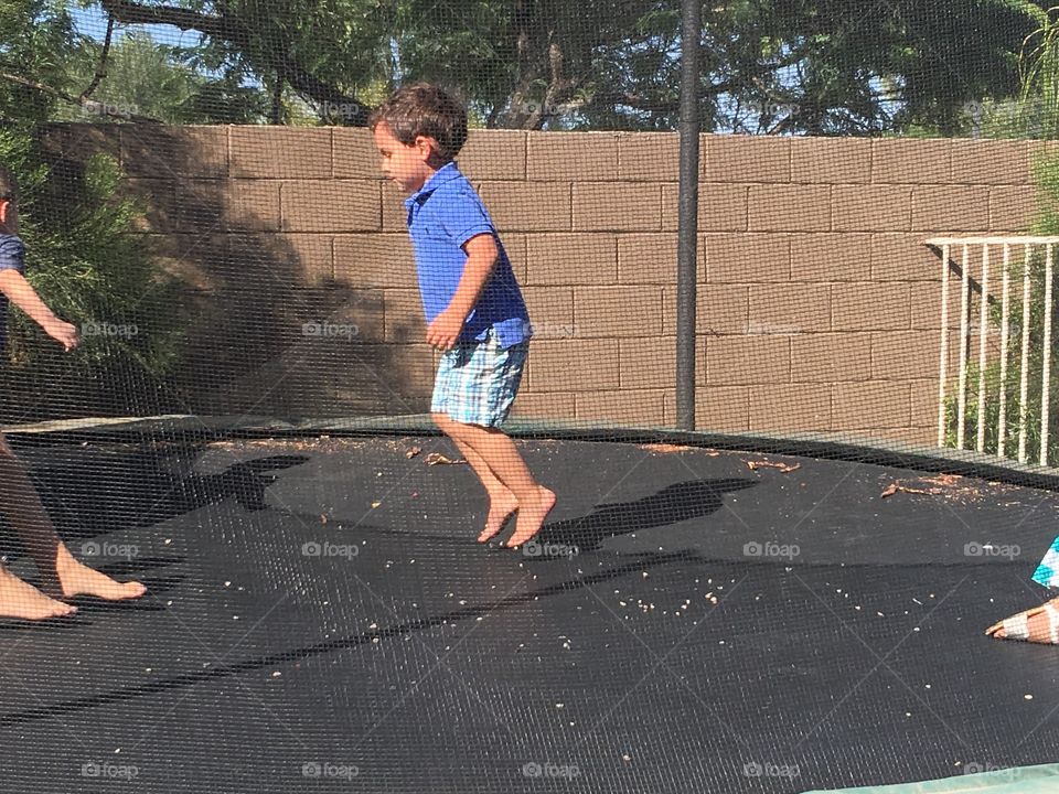 Boy jumping on trampoline,