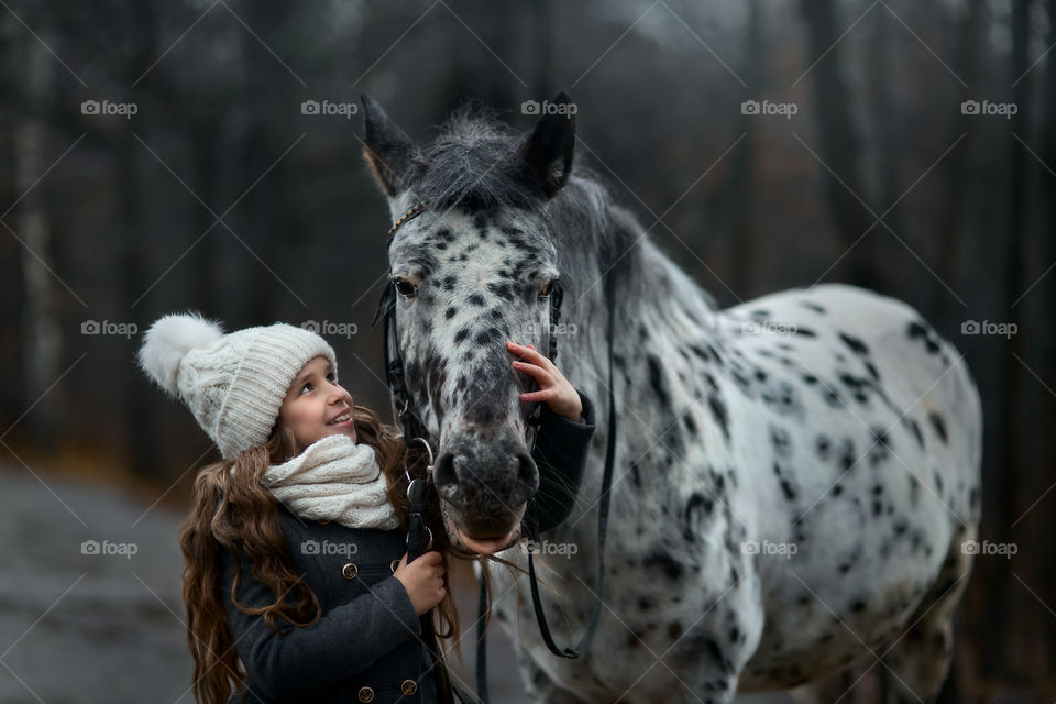Twins girls with Appaloosa horse  in autumn park 