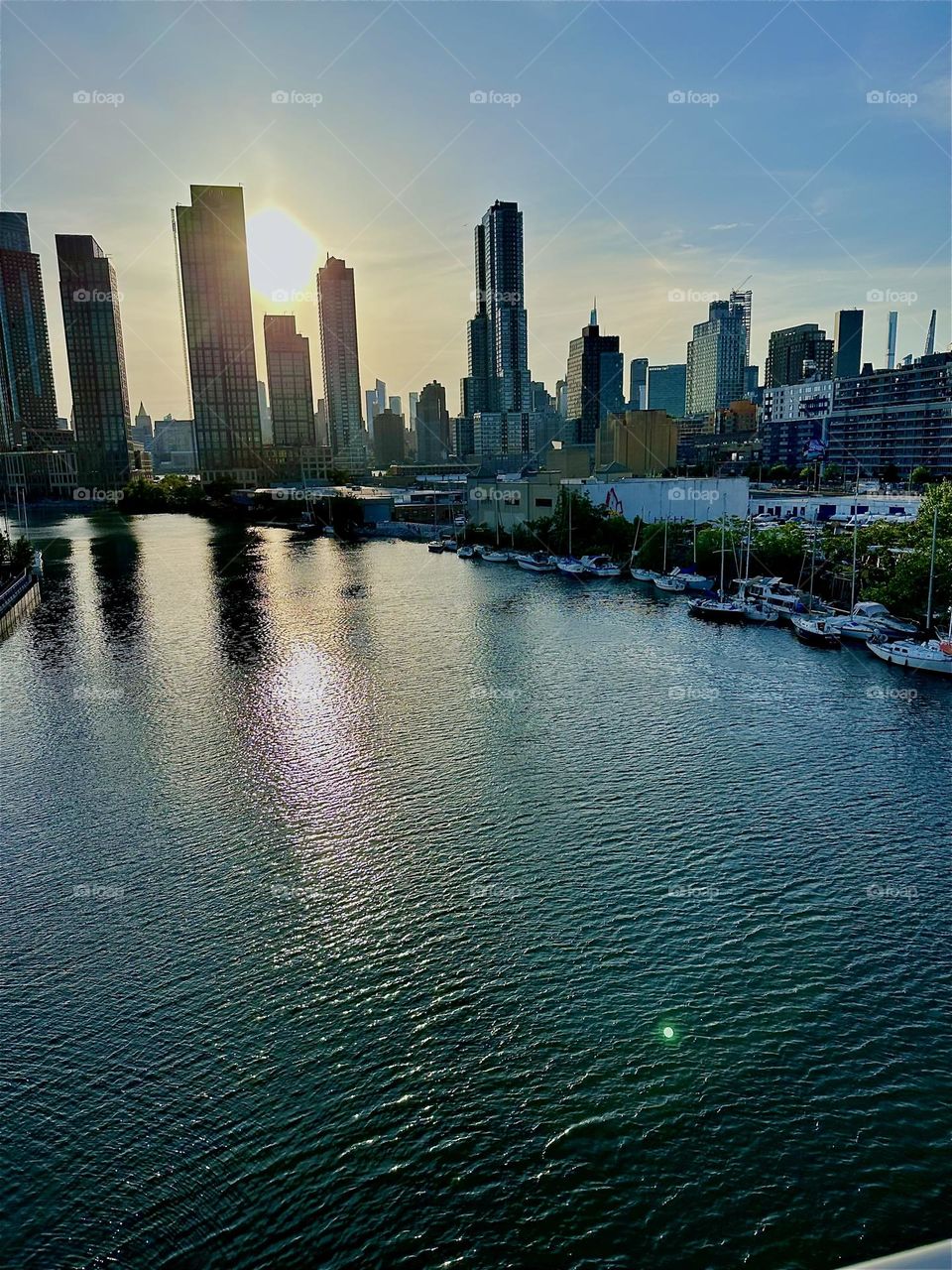 This is “Newtown Creek”, an ocean inlet of the “East River” seen from the “Pulaski Bridge” that connects “Greenpoint”, Bklyn to LIC, Queens. Across the water in the distance we see “Manhattan”. 2024. Hypnotic Productions