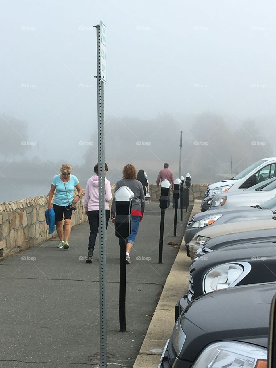 People walking foggy boardwalk Plymouth MA beach. Goes for few miles, to The Mayflower & Plymouth Rock!