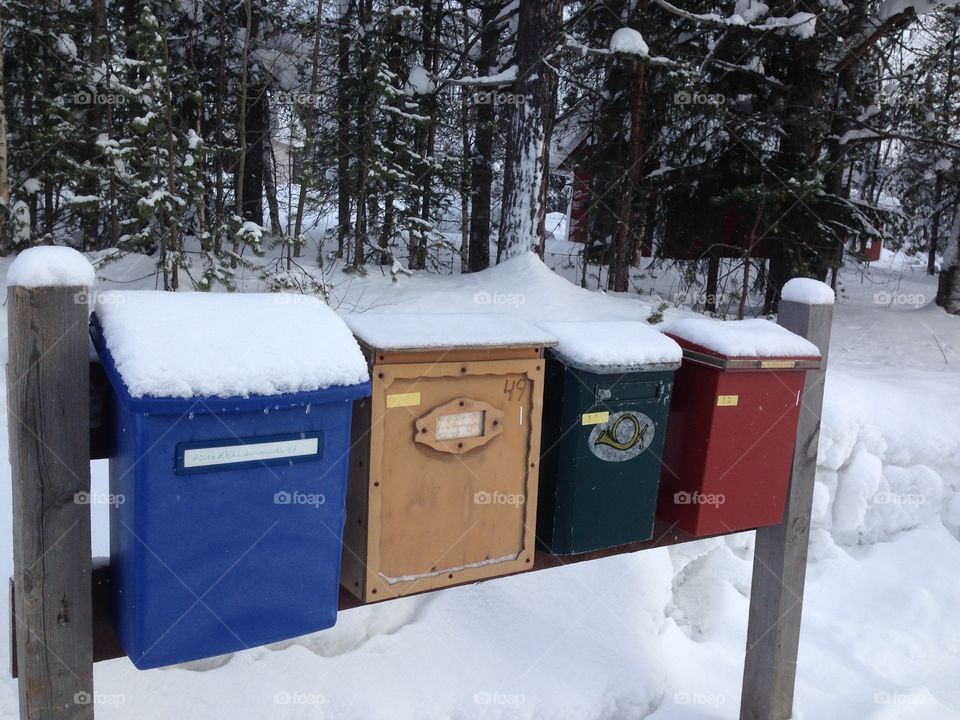 Four different mail boxes covered with snow in Finland.