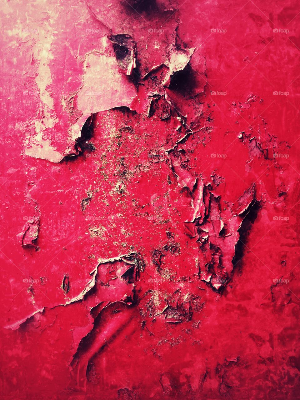 A texture background of blistered and peeling red paint on metal or wood